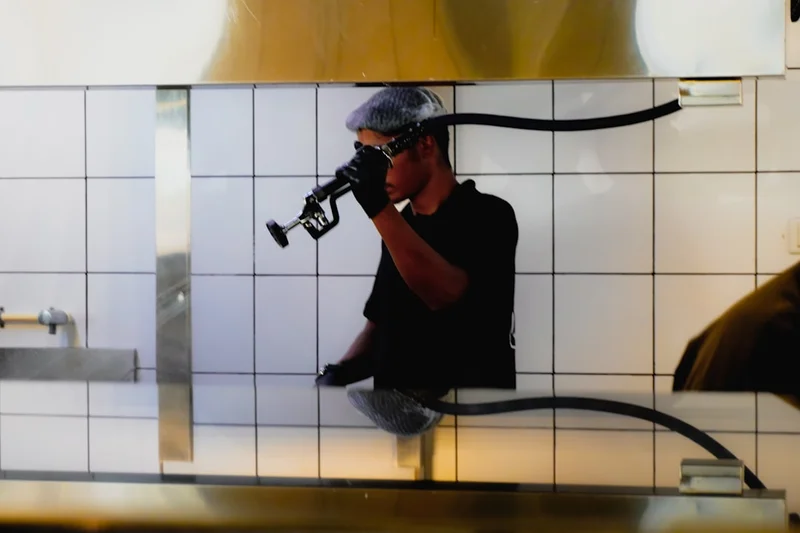 A person in black shirt and gloves examining equipment